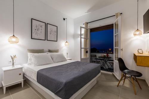 a bedroom with a large bed and a balcony at Uncle John's Guesthouse in Skopelos Town
