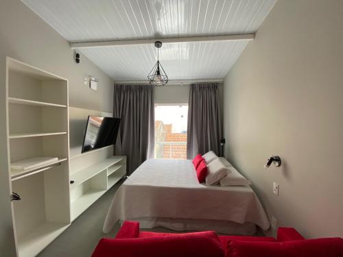 a bedroom with a bed with red pillows at Waikiki Apartament Ipanema in Rio de Janeiro