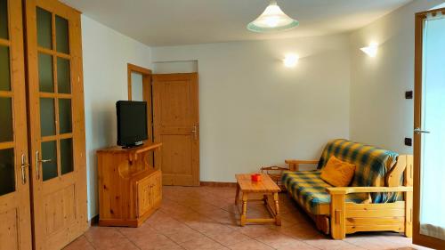 a living room with a couch and a tv at CASA EMMA in Mezzana