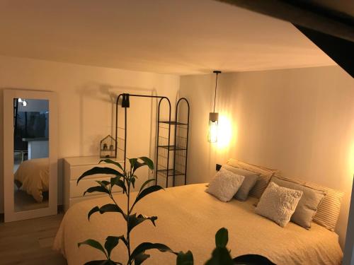 ein Schlafzimmer mit einem Bett mit weißer Bettwäsche und einer Pflanze in der Unterkunft Precioso Loft a 150 metros de la playa in Santa Pola