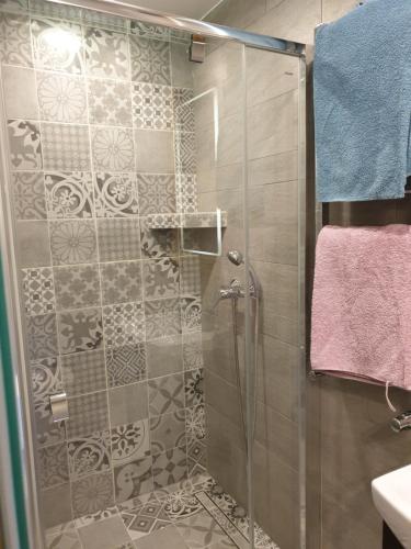 La salle de bains est pourvue d'une douche avec une porte en verre. dans l'établissement Izba w centrum miasta, à Zakopane