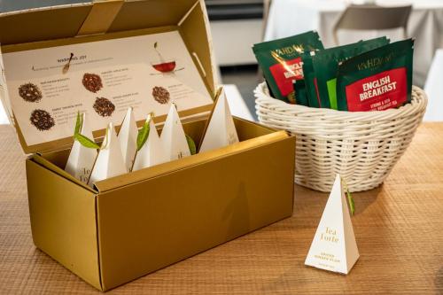 a box of treats and a basket of books on a table at My Suite Hotel in LʼAquila