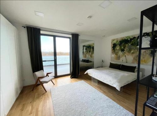 a bedroom with a bed and a large window at Modernes Apartment mit wunderschonem Rheinblick in Urmitz
