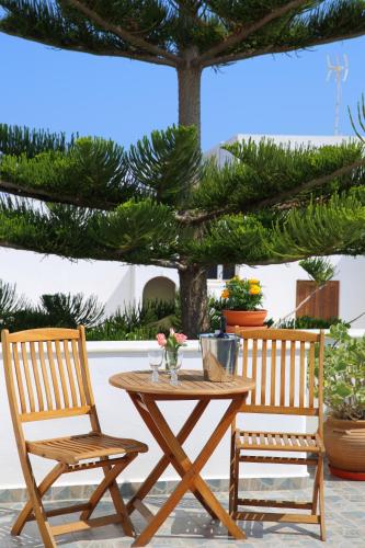 two chairs and a wooden table and a table and chairs at Pension Anna in Naousa