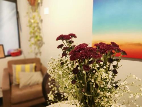 a vase of flowers on a table in a living room at Hospedaria Casa373 valores acessíveis Vila Mariana e Vila Clementino in Sao Paulo