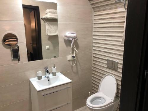 a bathroom with a toilet and a sink and a mirror at Zajazd Podzamcze in Olkusz