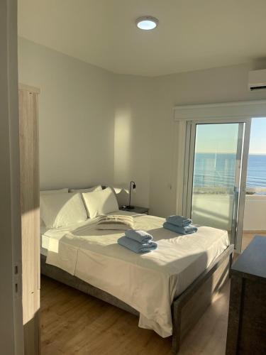 a bedroom with a bed with a view of the ocean at Alex Beach Apartment 34 in Larnaca