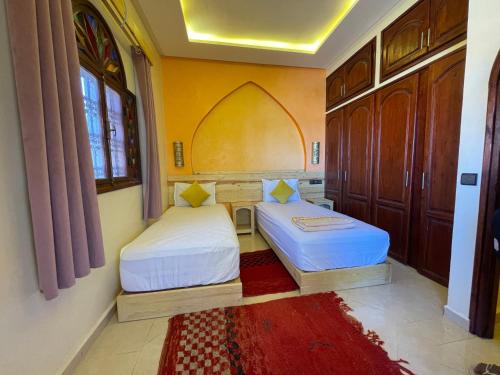 a bedroom with two beds in a room at Dromadaire Gourmand in Zagora