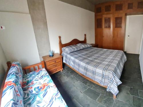 une chambre avec deux lits et une commode et un lit sidx sidx dans l'établissement Ap da Mama, à Guarujá