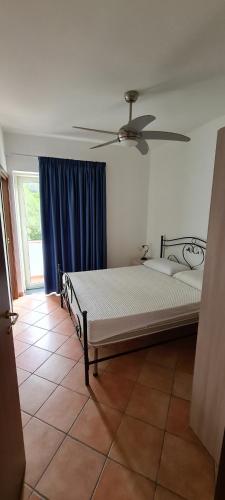 a bedroom with a bed with a ceiling fan at Wild Cilento in Castellabate