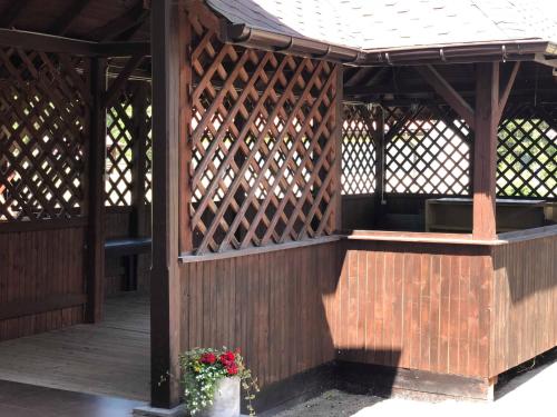 a wooden gazebo with a potted plant at Zajazd Podzamcze in Olkusz