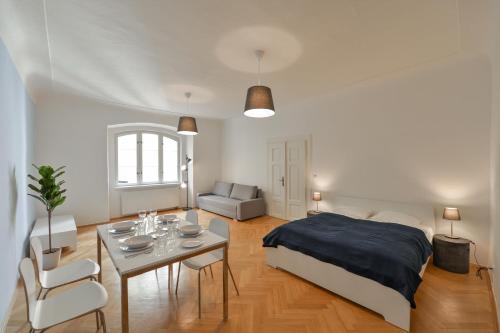 een slaapkamer met een bed en een tafel en stoelen bij Celetná 27 Residence in Praag
