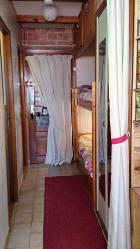 um pequeno quarto com uma cama e uma cortina em Studio rénové jardin et vue - 1 chambre - 4 nuits minimum em Chaillol