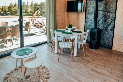 a room with a table and chairs and a balcony at Wierzbowa przystań in Czchów