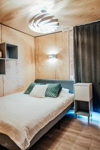 a bedroom with a large bed with a ceiling at Wierzbowa przystań in Czchów