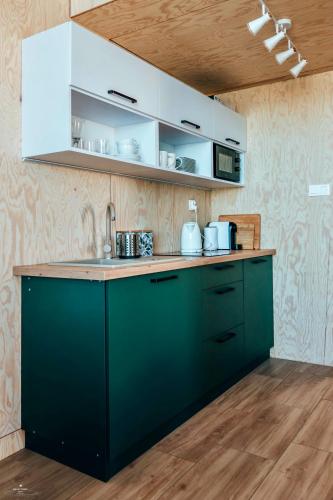 a kitchen with green cabinets and a counter top at Wierzbowa przystań in Czchów