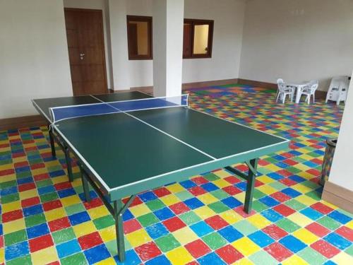 a ping pong table in a room with a colorful floor at Loft Res Pedra Azul - hospedagem nas montanhas in Pedra Azul