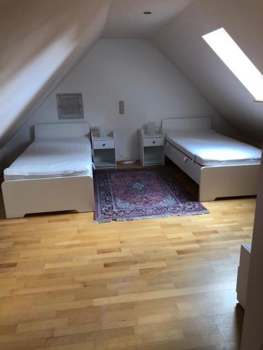 a attic room with two beds and a rug at Constantin in Bochum