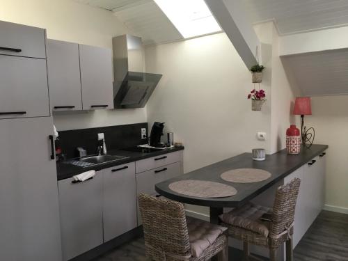 a kitchen with a table and chairs and a sink at Les Gîtes du Lachat in Saint-Sylvestre