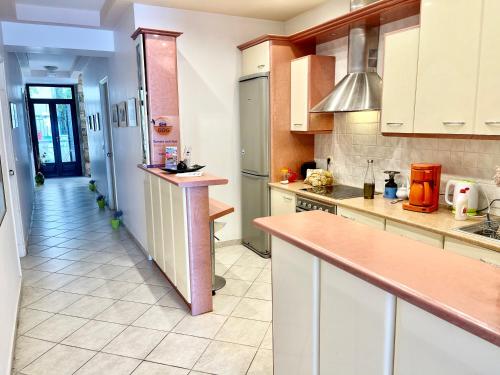 a kitchen with white cabinets and a long hallway at Xenios Zeus Rooms in Koroni