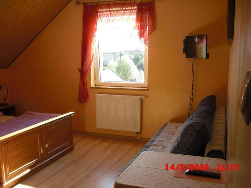 a living room with a bed and a window at Pokoje Gościnne HANA in Wünschelburg