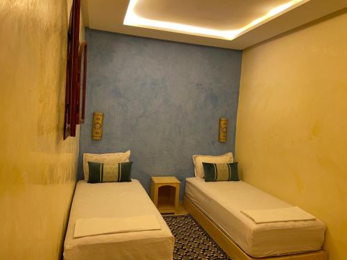 a room with two beds in a room at Dromadaire Gourmand in Zagora