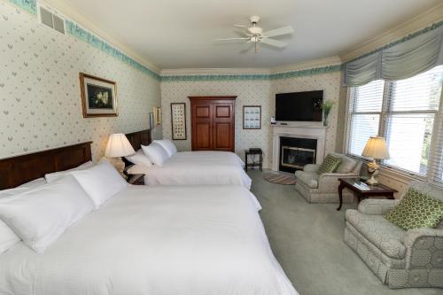 a large bedroom with two beds and a fireplace at Oakmont Inn in Verona