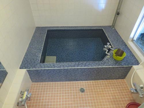 y baño con bañera y suelo de baldosa. en Hotel Marue - Vacation STAY 76469v en Kamaishi