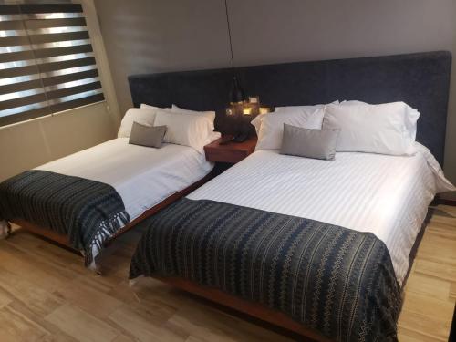 two beds sitting next to each other in a bedroom at Hotel Arista 1026 in San Luis Potosí