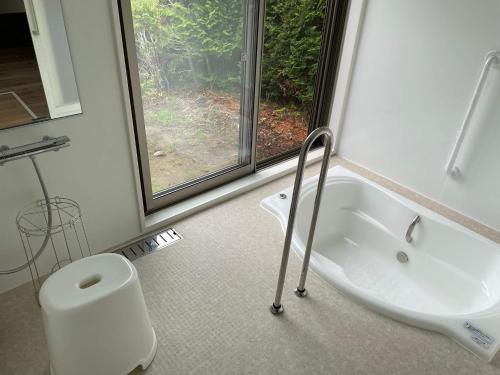 ein Bad mit einem Waschbecken, einem WC und einem Fenster in der Unterkunft Rental villa, Otomi's house - Vacation STAY 11993 in Kimitsu