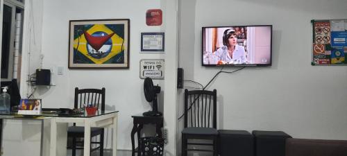 um quarto com cadeiras e uma televisão na parede em Pousada Savoy em Fortaleza