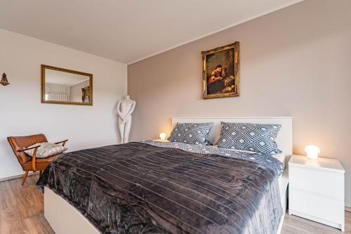 a bedroom with a large bed and a chair at Architektenwohnungen mit Panoramablick bei Köln in Lindlar