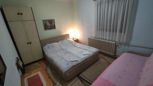 Habitación pequeña con cama y ventana en Prenoćište Dika, en Višegrad