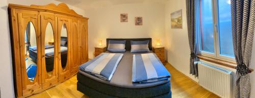 sypialnia z łóżkiem i drewnianą szafką w obiekcie Ferienwohnung Südpfalzblick w mieście Burrweiler