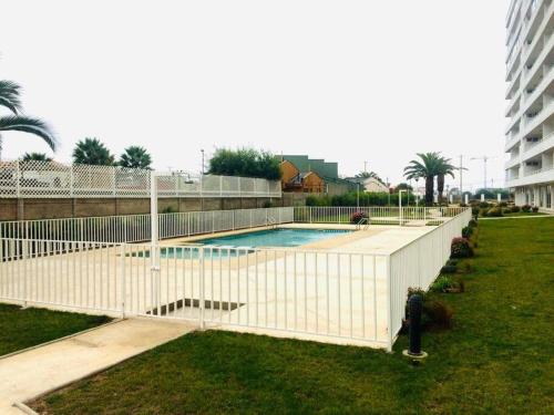 una valla blanca alrededor de una piscina en un patio en Condominio Terrazas del Sol, La Serena, en La Serena