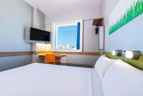 a hotel room with a television and a bed at Ibis Budget Fortaleza Praia de Iracema in Fortaleza