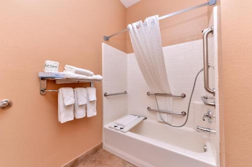 a bathroom with a tub and a shower with towels at Candlewood Suites San Diego, an IHG Hotel in San Diego