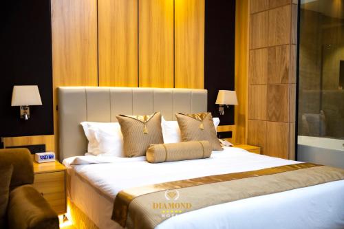 a hotel room with a large white bed with pillows at Hotel Diamond Prishtina in Pristina