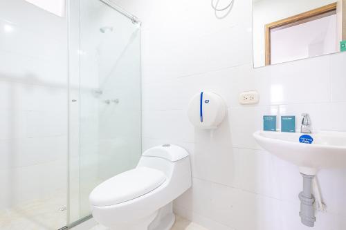 a white bathroom with a toilet and a sink at Ayenda 1501 Metropolitana Plaza in Bucaramanga