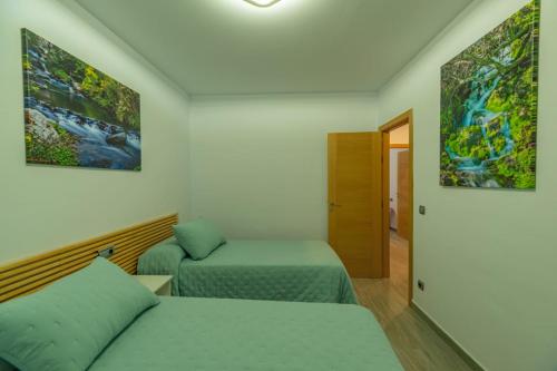 Habitación con 2 camas y pasillo. en CASA ANGEL PAMPANEIRA 3 HAB 2 BAÑOS FACIL ACCESO, en Pampaneira