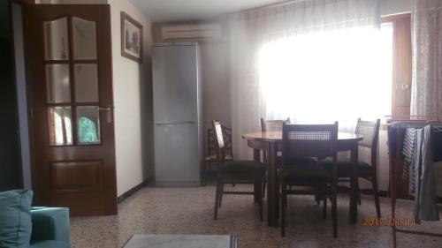 d'une salle à manger avec une table, des chaises et une fenêtre. dans l'établissement PISO PILARES 6-10 PAX. PARQUE DELICIAS, à Saragosse