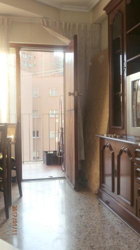 une porte ouverte donnant sur une cuisine avec vue sur un bâtiment dans l'établissement PISO PILARES 6-10 PAX. PARQUE DELICIAS, à Saragosse