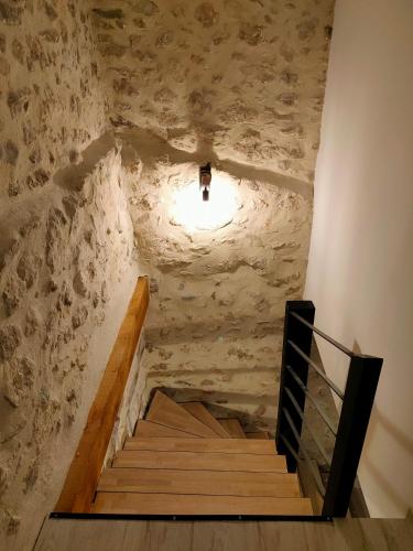 a staircase in a room with a stone wall at L'envoûtement Provençal, jacuzzi privatif et SPA in Orgon