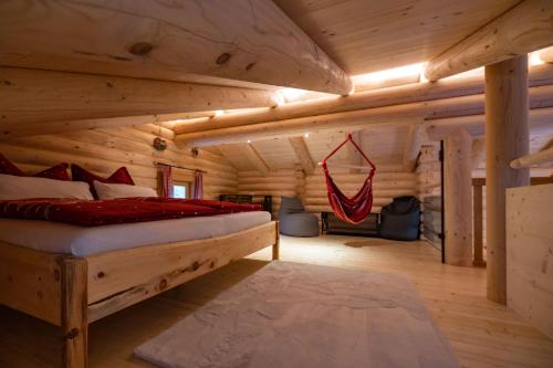 1 dormitorio con 1 cama en una cabaña de madera en Connys Naturberghütten, en Großkirchheim