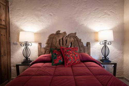 a bedroom with a large red bed with two lamps at Oasis in San Miguel in San Miguel de Allende