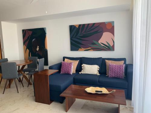 sala de estar con sofá azul y mesa en **STUNNING **BRAND NEW APART ON 5TH AVE (NEW AREA), en Playa del Carmen