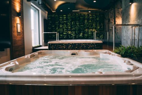 ein Whirlpool in einem Zimmer mit Fenster in der Unterkunft FOLGA - Hotel, Restauracja, Browar, SPA in Gryfice