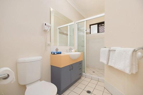 a bathroom with a white toilet and a sink at Central Plaza Apartments in Cairns