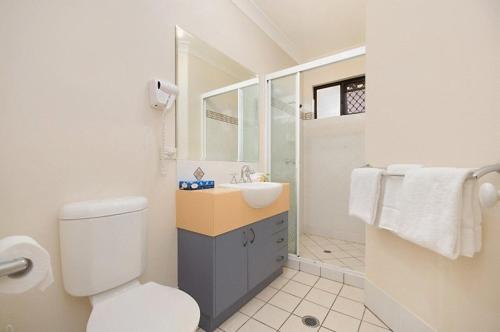 une salle de bain avec des toilettes blanches et un lavabo dans l'établissement Central Plaza Apartments, à Cairns