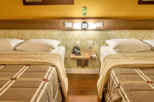 Llit o llits en una habitació de Hotel 10 Blumenau